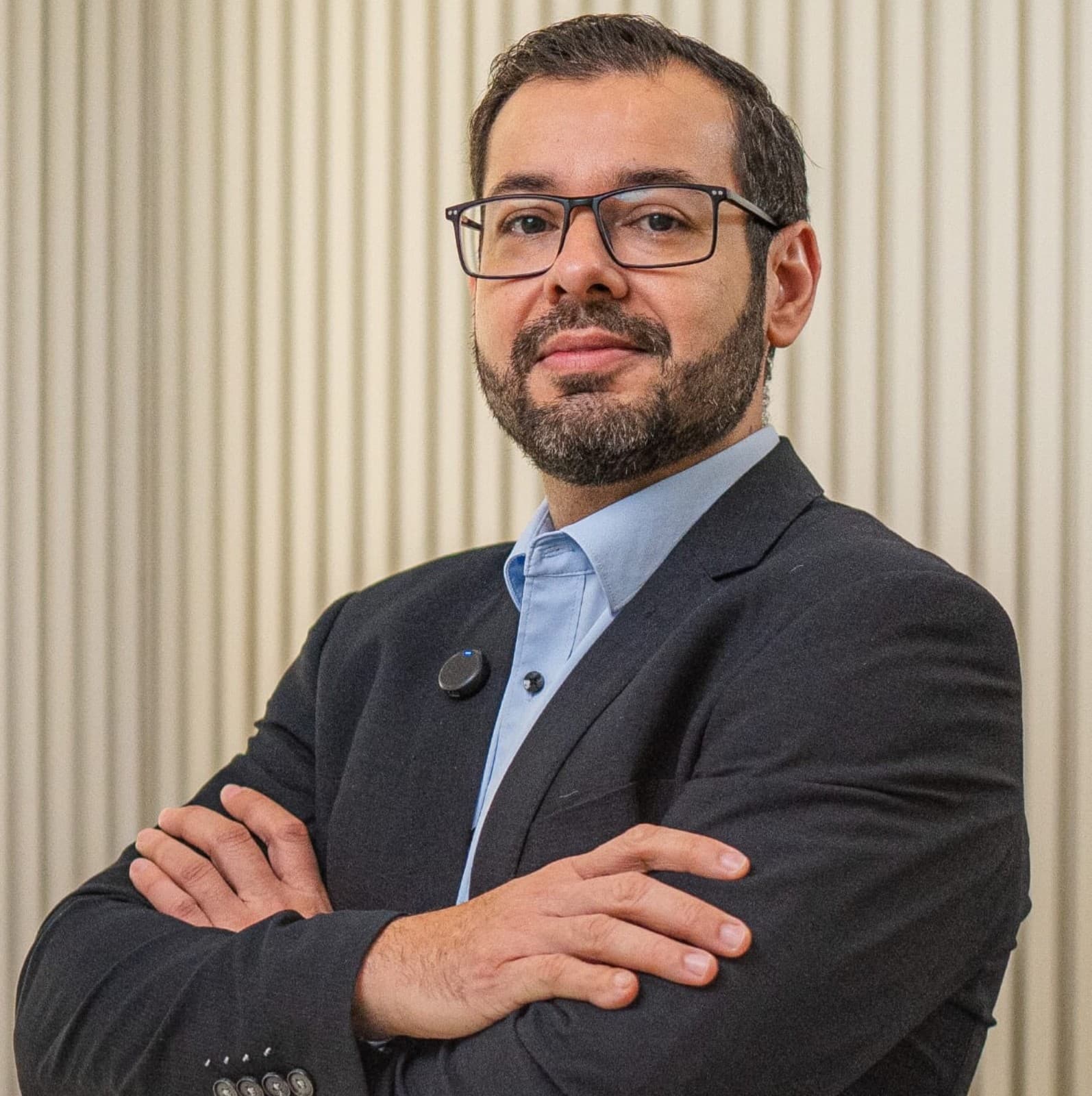 Doutor Clovis Fagundes Botelho, Graduado em Medicina pelo Centro Universitário de Várzea Grande, com especialização em Medicina Intensiva. Ele está sorrindo e usa camisa social com gravata. Ao redor do seu pescoço tem  um aparelho de medir pressão dos pacientes.